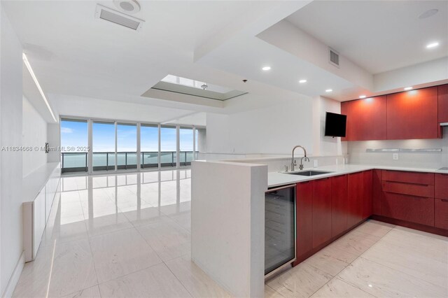1331 Brickell Bay Dr Unit 2705, Miami, FL 33131 - kitchen with a wall of windows, modern cabinets, a peninsula, beverage cooler, and light countertops