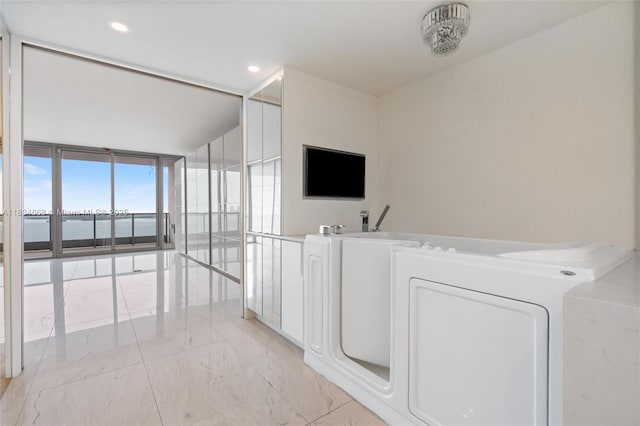 1331 Brickell Bay Dr Unit 2705, Miami, FL 33131 - corridor with a wall of windows, washer / clothes dryer, light marble finish floors, and recessed lighting