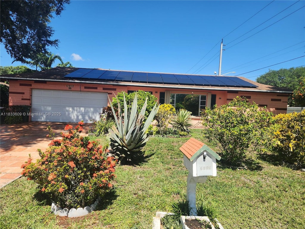 6900 NW 94th Ave, Tamarac, FL 33321 - single story home featuring a garage, roof mounted solar panels, driveway, and a front yard