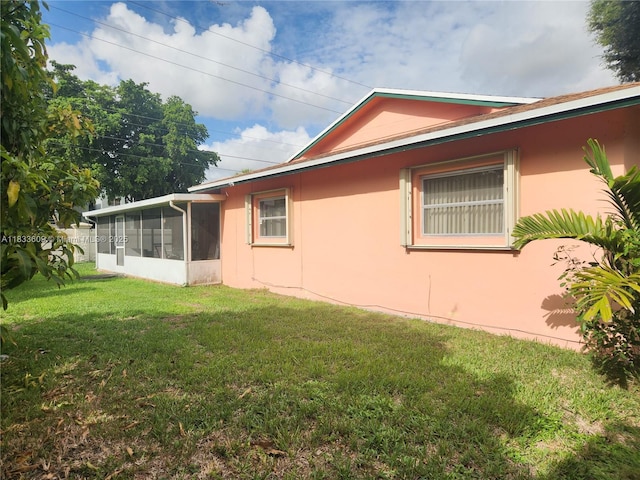 6900 NW 94th Ave, Tamarac, FL 33321 - view of home's exterior with a sunroom, stucco siding, and a yard