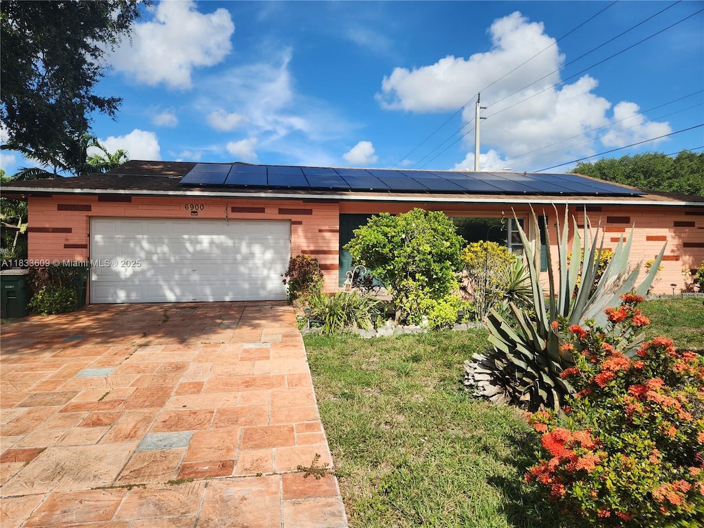 6900 NW 94th Ave, Tamarac, FL 33321 - view of front of house with roof mounted solar panels, a garage, and driveway