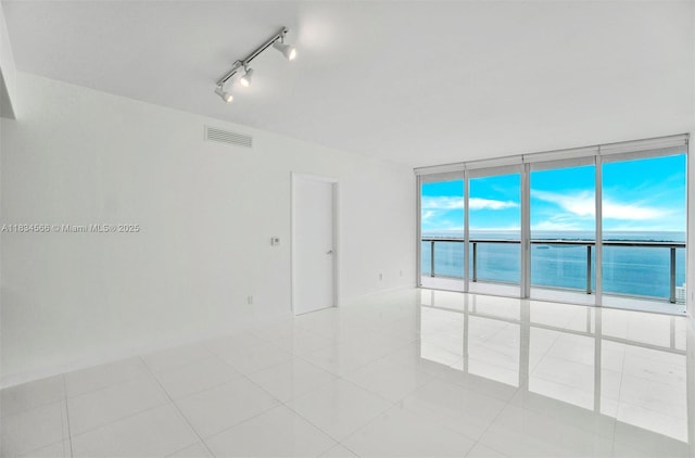 465 Brickell Ave Unit 4505, Miami, FL 33131 - empty room with floor to ceiling windows, a water view, light tile patterned flooring, and track lighting