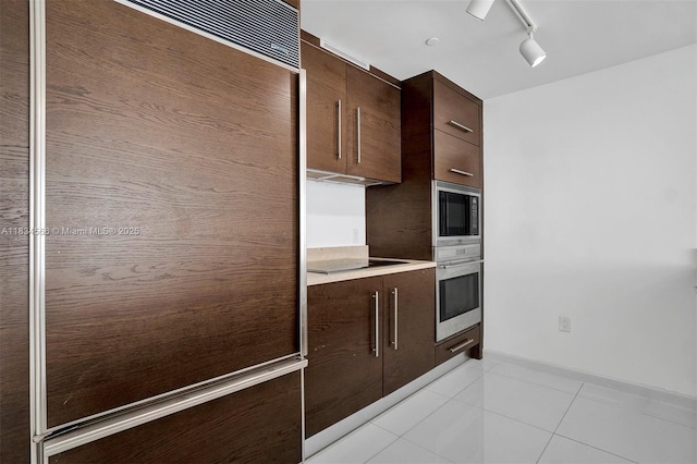 465 Brickell Ave Unit 4505, Miami, FL 33131 - kitchen with black appliances, dark brown cabinetry, modern cabinets, and light tile patterned flooring