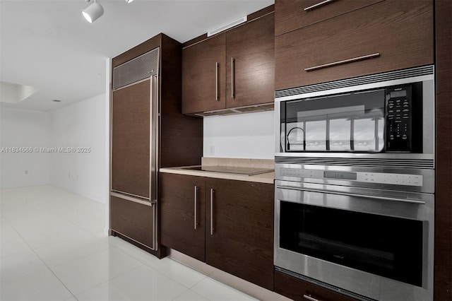 465 Brickell Ave Unit 4505, Miami, FL 33131 - kitchen featuring built in appliances, dark brown cabinetry, light countertops, and light tile patterned floors