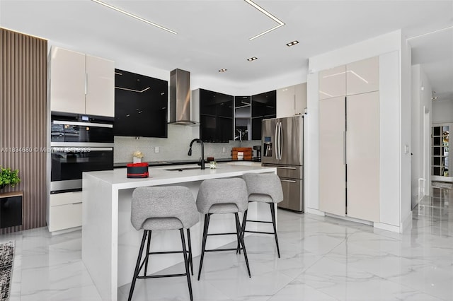 2036 SW 159th Ave, Miramar, FL 33027 - kitchen featuring appliances with stainless steel finishes, wall chimney exhaust hood, modern cabinets, a breakfast bar, and light countertops