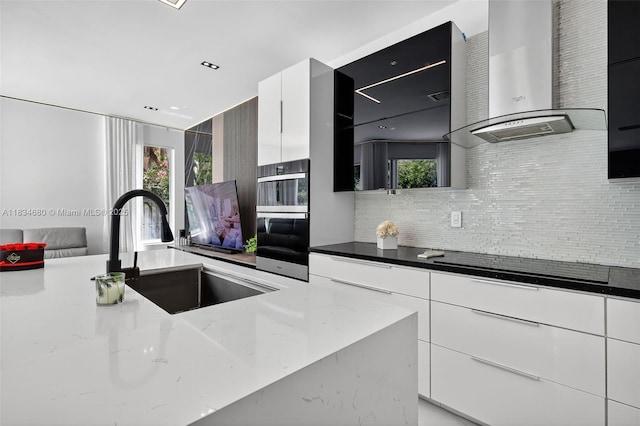 2036 SW 159th Ave, Miramar, FL 33027 - kitchen featuring wall chimney range hood, decorative backsplash, and modern cabinets