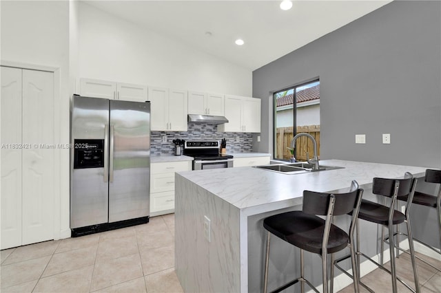 22486 SW 110th Ct, Miami, FL 33170 - kitchen featuring appliances with stainless steel finishes, under cabinet range hood, backsplash, a kitchen breakfast bar, and light countertops