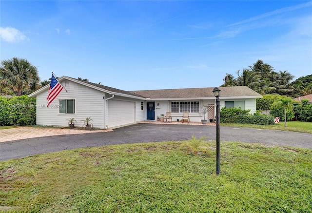 7735 Edgewater Dr, Lake Clarke Shores, FL 33406 - ranch-style home with driveway, an attached garage, and a front yard