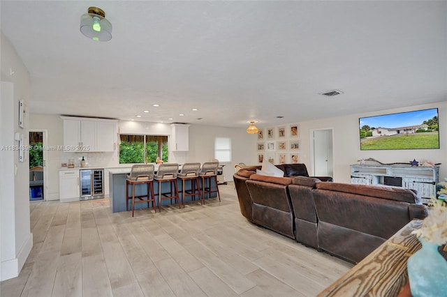 7735 Edgewater Dr, Lake Clarke Shores, FL 33406 - living area featuring beverage cooler, light wood-type flooring, recessed lighting, and a fireplace