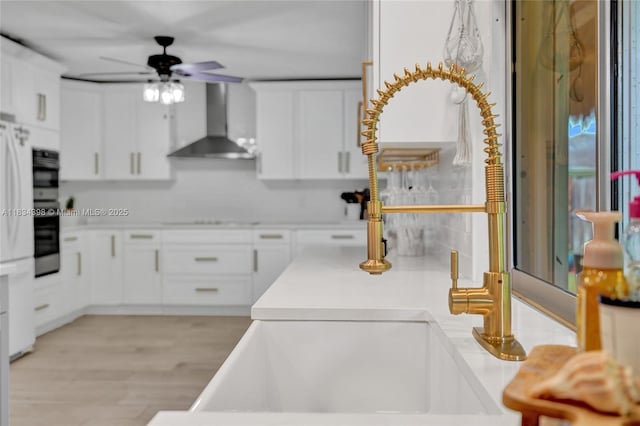 7735 Edgewater Dr, Lake Clarke Shores, FL 33406 - kitchen featuring wall chimney range hood, white cabinetry, ceiling fan, light countertops, and stovetop