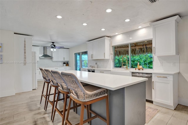 7735 Edgewater Dr, Lake Clarke Shores, FL 33406 - kitchen with dishwasher, wall chimney exhaust hood, recessed lighting, ceiling fan, and white cabinets
