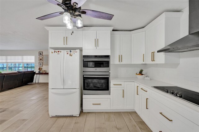 7735 Edgewater Dr, Lake Clarke Shores, FL 33406 - kitchen featuring freestanding refrigerator, wall chimney exhaust hood, stainless steel double oven, light wood finished floors, and a ceiling fan