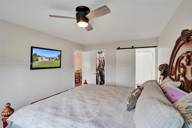 7735 Edgewater Dr, Lake Clarke Shores, FL 33406 - bedroom featuring a barn door, a walk in closet, ceiling fan, and a closet