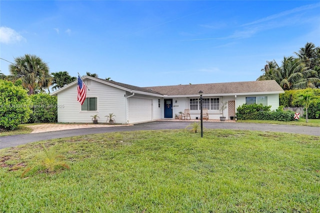 7735 Edgewater Dr, Lake Clarke Shores, FL 33406 - ranch-style home with asphalt driveway, a garage, a front lawn, and covered porch