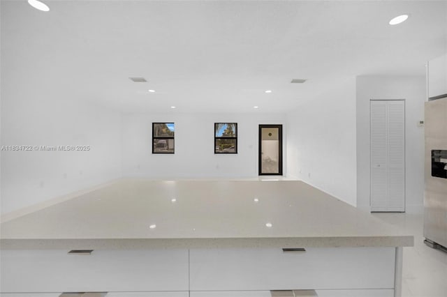 324 SW 16th Ter, Homestead, FL 33030 - kitchen featuring recessed lighting, light stone counters, white cabinetry, modern cabinets, and refrigerator with ice dispenser