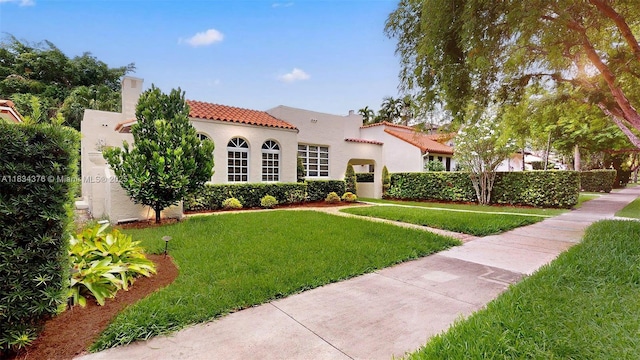 1111 Columbus Blvd, Coral Gables, FL 33134 - mediterranean / spanish house featuring stucco siding, a tiled roof, a front lawn, and a chimney