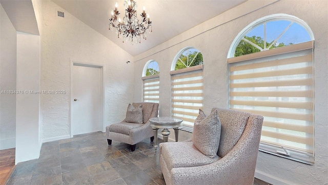 1111 Columbus Blvd, Coral Gables, FL 33134 - sitting room featuring stone tile flooring, a textured wall, a chandelier, and high vaulted ceiling