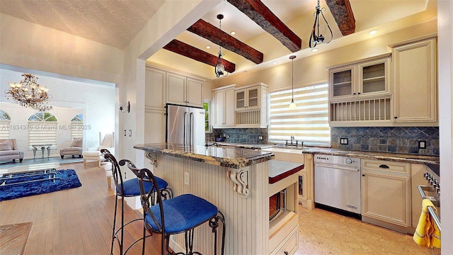 1111 Columbus Blvd, Coral Gables, FL 33134 - kitchen with appliances with stainless steel finishes, cream cabinetry, beamed ceiling, a breakfast bar area, and open floor plan