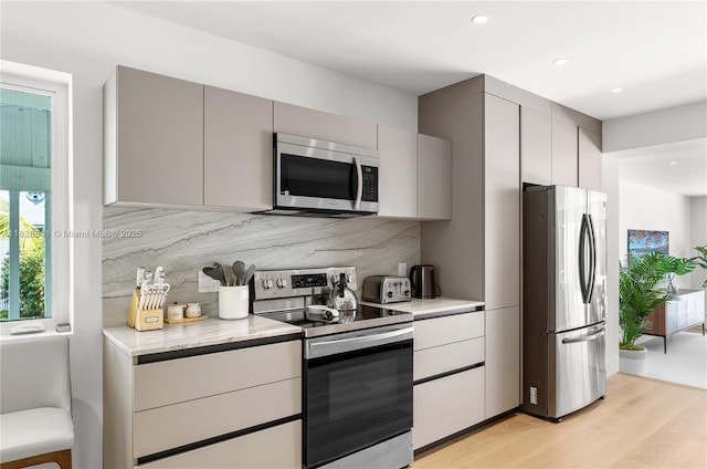 45 NE 104th St, Miami Shores, FL 33138 - kitchen with appliances with stainless steel finishes, tasteful backsplash, light wood-style floors, gray cabinetry, and recessed lighting