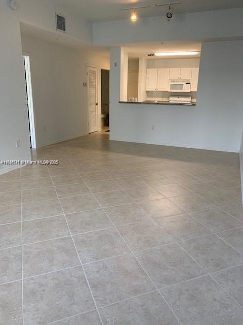 1209 Main St Unit 215, Jupiter, FL 33458 - unfurnished living room featuring light tile patterned flooring and track lighting