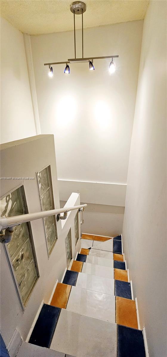 3494 E 4th Ave Unit 1207, Hialeah, FL 33013 - stairway featuring a textured ceiling and tile patterned floors
