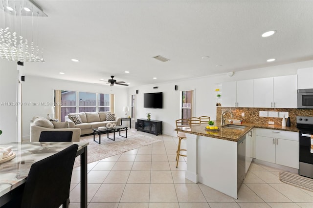 1894 SW 149th Ave, Miramar, FL 33027 - kitchen featuring appliances with stainless steel finishes, a kitchen bar, a peninsula, decorative backsplash, and recessed lighting