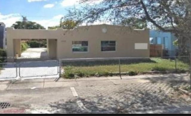 1770 NW 44th St, Miami, FL 33142 - view of front facade featuring stucco siding and a fenced front yard