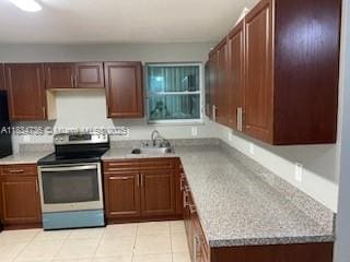 1770 NW 44th St, Miami, FL 33142 - kitchen featuring stainless steel electric range oven, light countertops, and light tile patterned floors