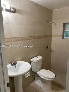 1770 NW 44th St, Miami, FL 33142 - full bath featuring tiled shower, tile patterned floors, and tile walls