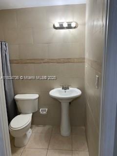1770 NW 44th St, Miami, FL 33142 - full bathroom with tile patterned floors, a shower with shower curtain, and tile walls