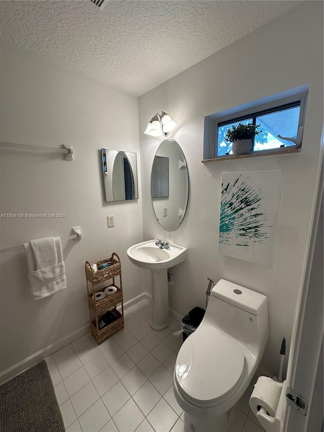 bathroom featuring tile patterned floors and a textured ceiling