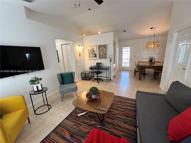 living area with light tile patterned flooring, vaulted ceiling, a chandelier, and ceiling fan