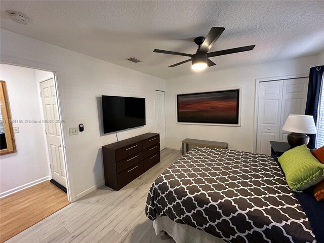 bedroom featuring light wood-style floors, a textured ceiling, and a ceiling fan