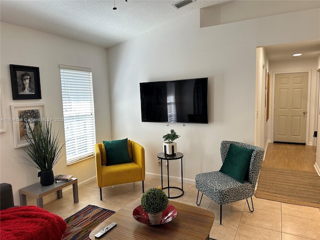 living area featuring light tile patterned floors and a textured ceiling