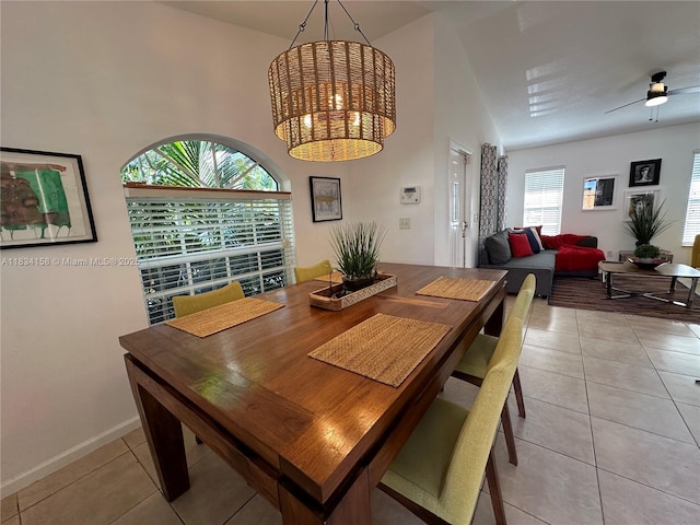 dining area with light tile patterned flooring, ceiling fan, and a chandelier