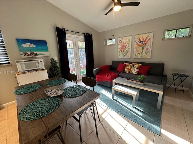 living area with a ceiling fan, lofted ceiling, light tile patterned flooring, and french doors