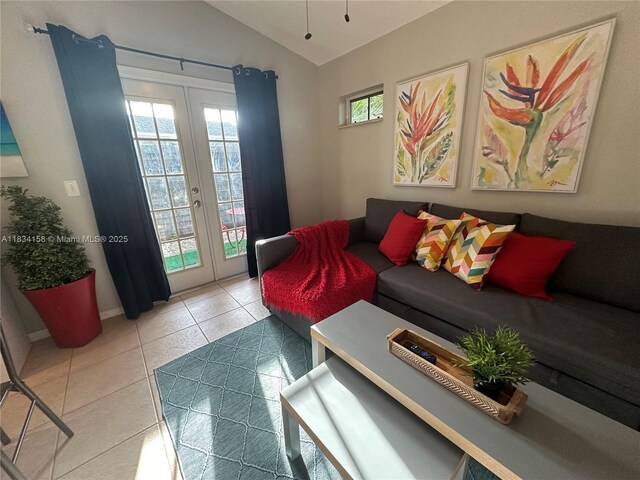 living room featuring french doors, lofted ceiling, and light tile patterned floors