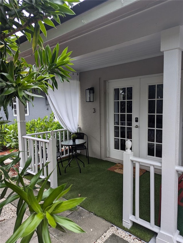 view of exterior entry with french doors and stucco siding