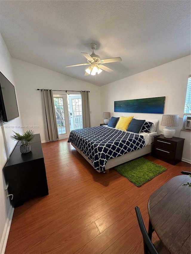 bedroom featuring wood finished floors, lofted ceiling, and a ceiling fan