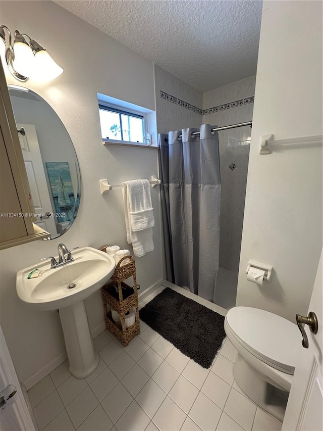 bathroom featuring a textured ceiling, tiled shower, and tile patterned floors