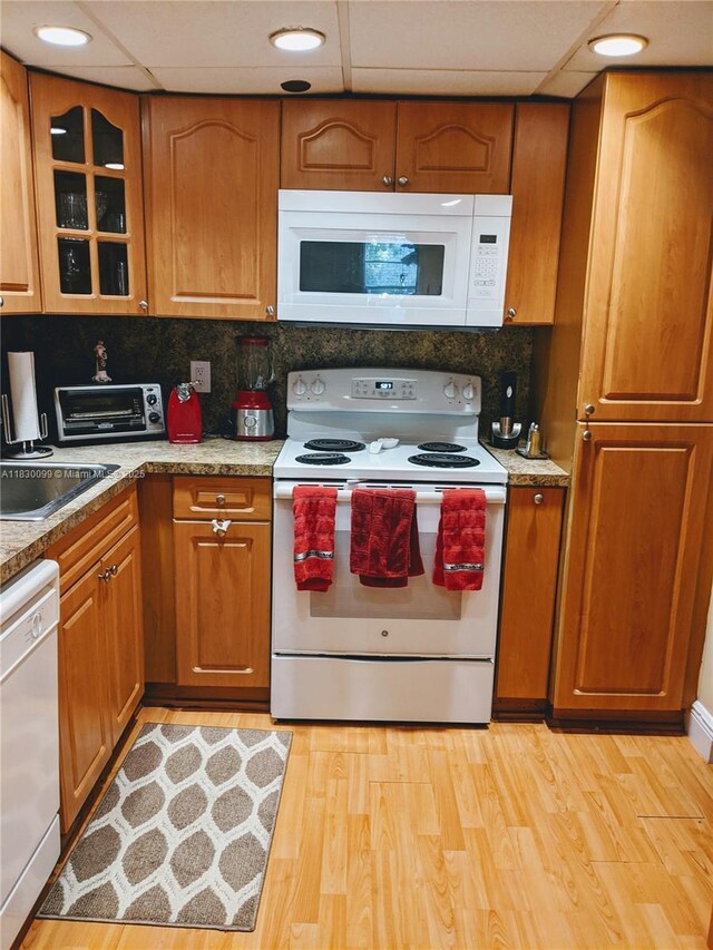 900 Saint Charles Pl Unit L6, Pembroke Pines, FL 33026 - kitchen featuring white appliances, brown cabinets, light wood finished floors, and a paneled ceiling