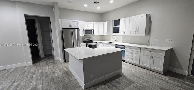 17186 N 84th Ct, Loxahatchee, FL 33470 - kitchen featuring stainless steel appliances, wood finished floors, a center island, light countertops, and recessed lighting