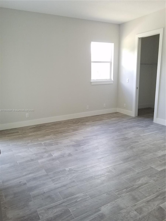 17186 N 84th Ct, Loxahatchee, FL 33470 - unfurnished bedroom with a spacious closet and wood finished floors
