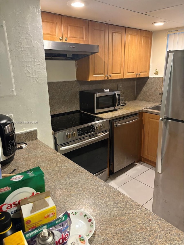 8841 W Flagler St Unit 103, Miami, FL 33174 - kitchen with appliances with stainless steel finishes, under cabinet range hood, light tile patterned flooring, recessed lighting, and brown cabinets