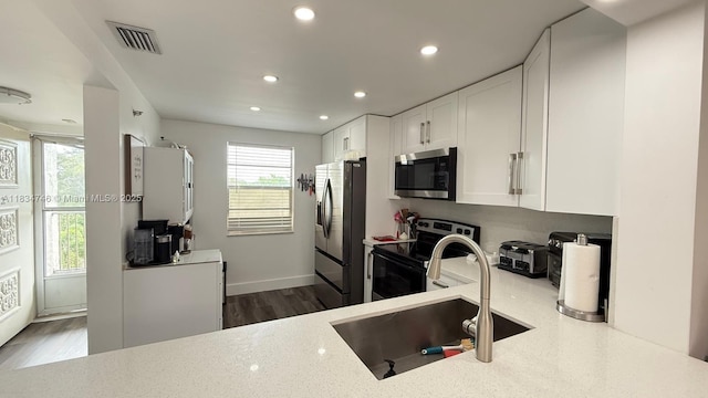 3910 Inverrary Blvd Unit 503-B, Lauderhill, FL 33319 - kitchen with stainless steel appliances, white cabinetry, recessed lighting, light stone countertops, and dark wood-style flooring