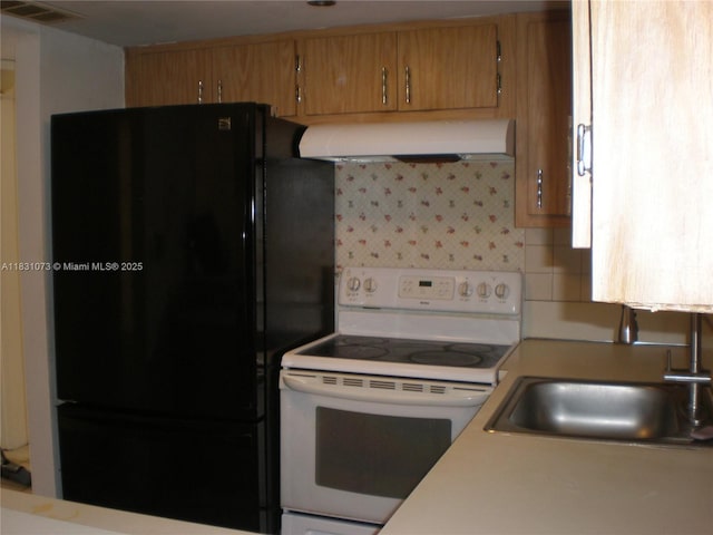 5855 Washington St Unit 92, Hollywood, FL 33023 - kitchen with white range with electric stovetop, freestanding refrigerator, exhaust hood, light countertops, and brown cabinetry