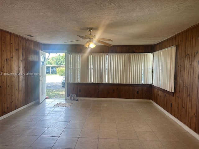 532 Bond, Clewiston, FL 33440 - tiled empty room with wood walls, ceiling fan, and a textured ceiling