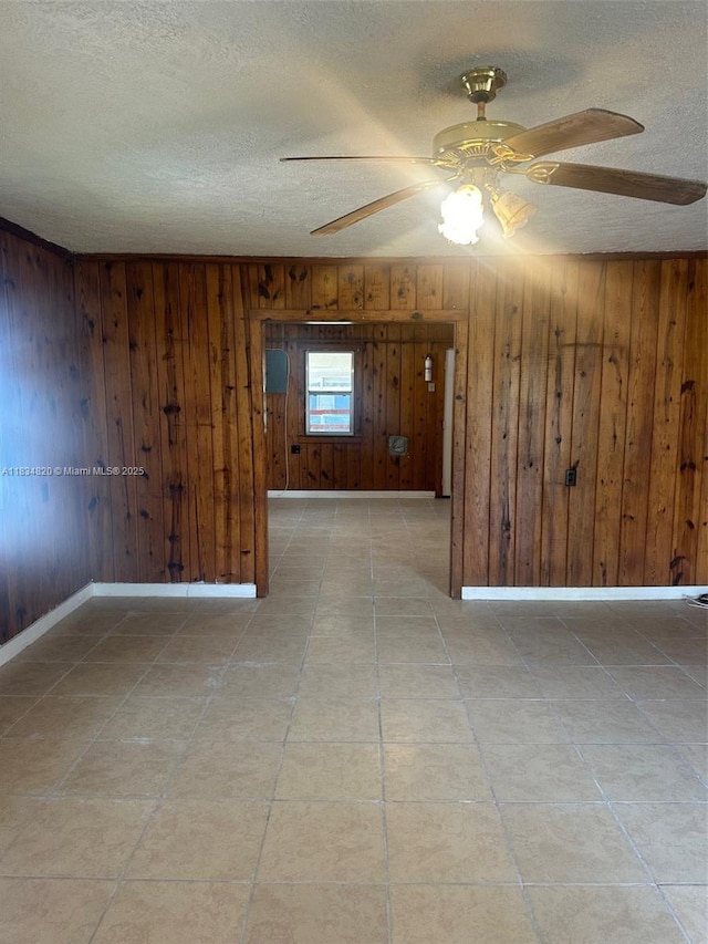 532 Bond, Clewiston, FL 33440 - empty room featuring a ceiling fan, a textured ceiling, and wood walls