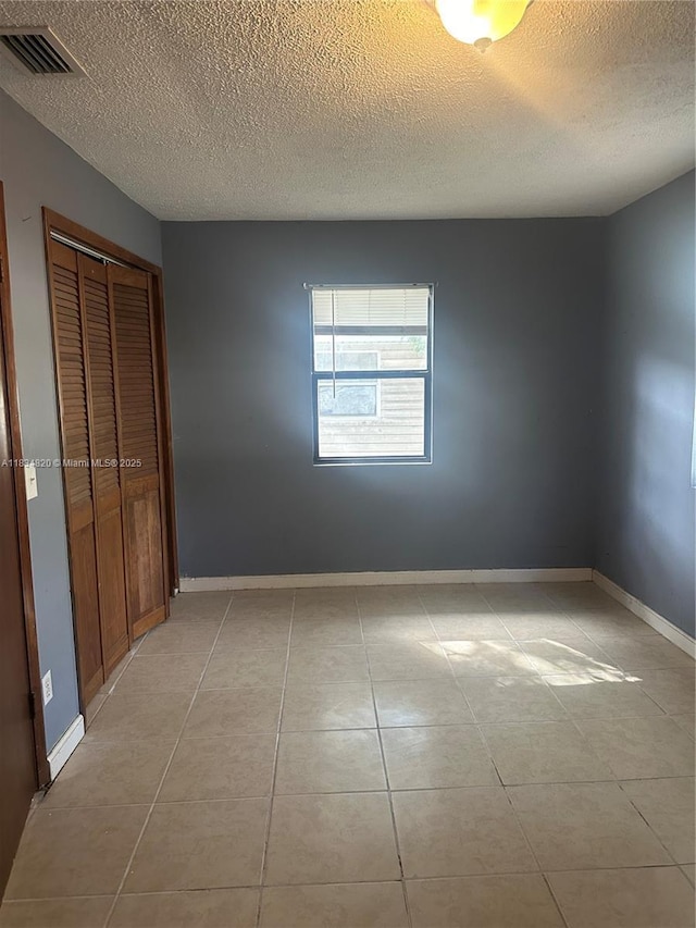 532 Bond, Clewiston, FL 33440 - unfurnished bedroom with a textured ceiling, a closet, and light tile patterned floors