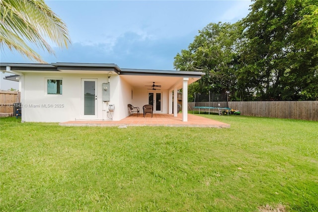 9471 SW 10th St, Miami, FL 33174 - back of property featuring a trampoline, ceiling fan, a fenced backyard, and stucco siding